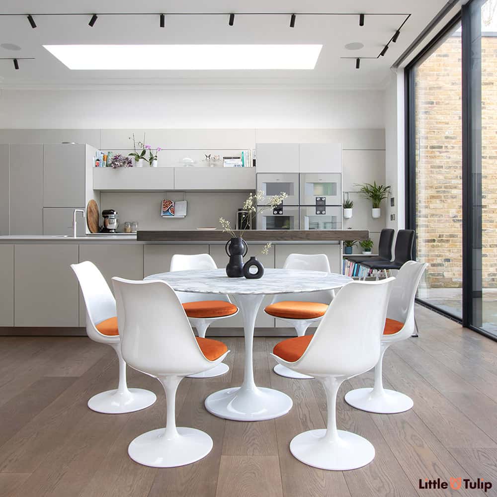 A dining set fit for a king and queen! A colour wave flashes from the burnt orange cushions of the 6 Tulip Side Chairs with the 120 cm Circular Tulip Table