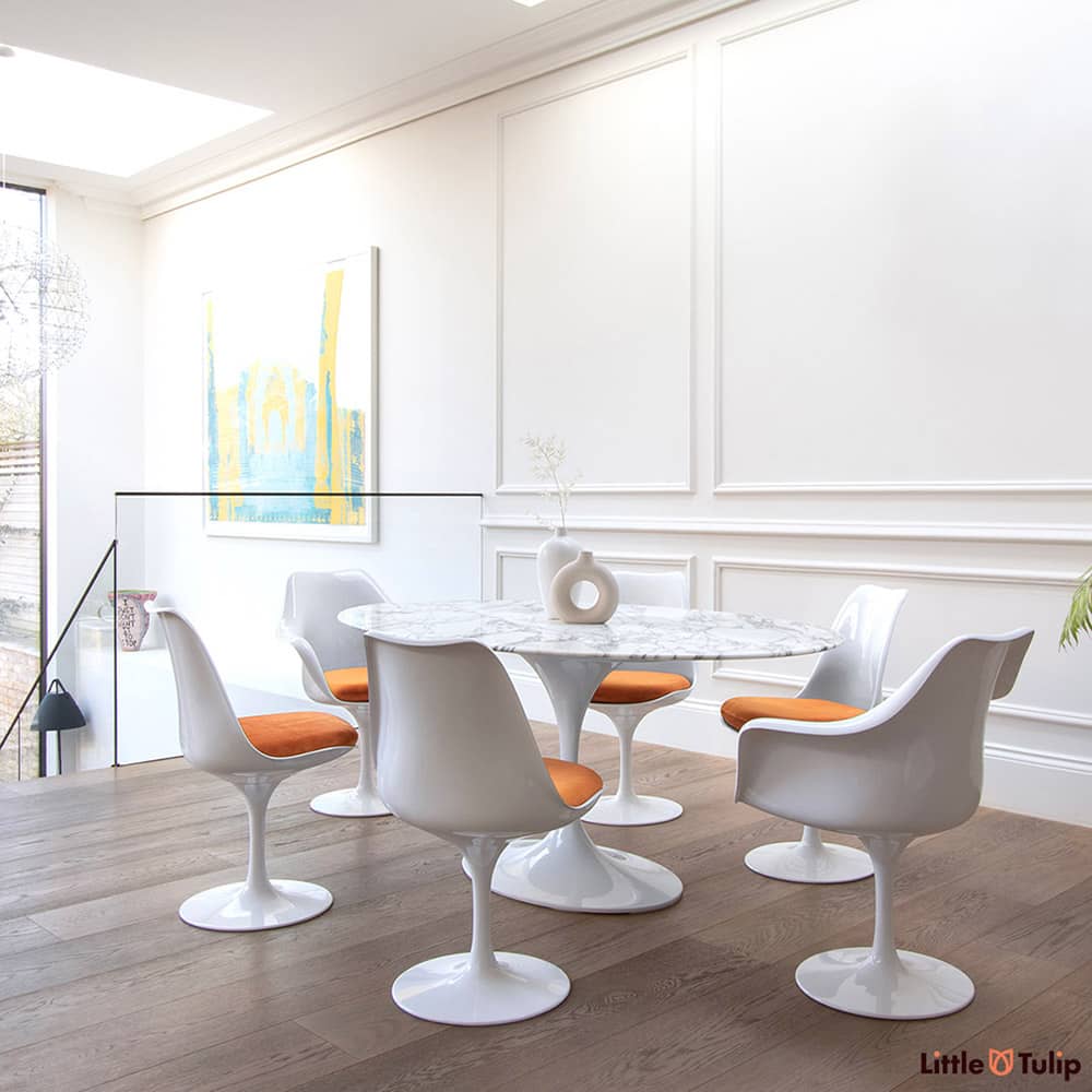 What a stunning presence the Oval Arabescato Tulip Table has in this gorgeous modern room, especially with Tulip Side, Arm chairs & blazing orange cushions