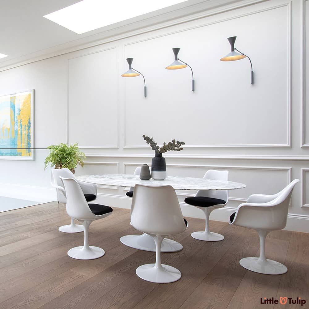 An absolutely gorgeous combination of white space and wooden floor is home to an Arabescato 200 cm Oval table with 4 side & 2 arm chairs with black cushions