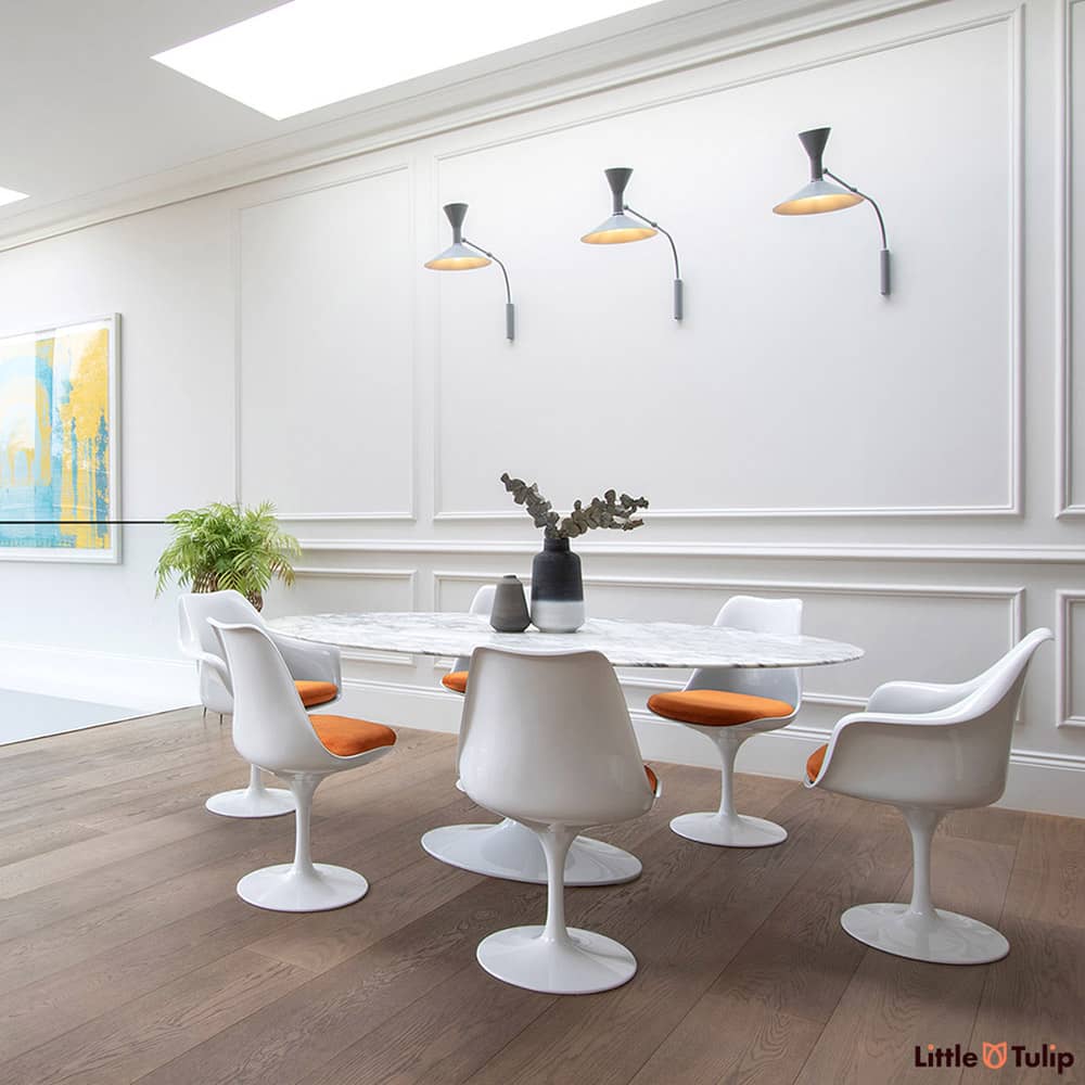 An absolutely gorgeous combination of white space and wooden floor is home to an Arabescato 200 cm Oval table with 4 side & 2 arm chairs with orange cushions