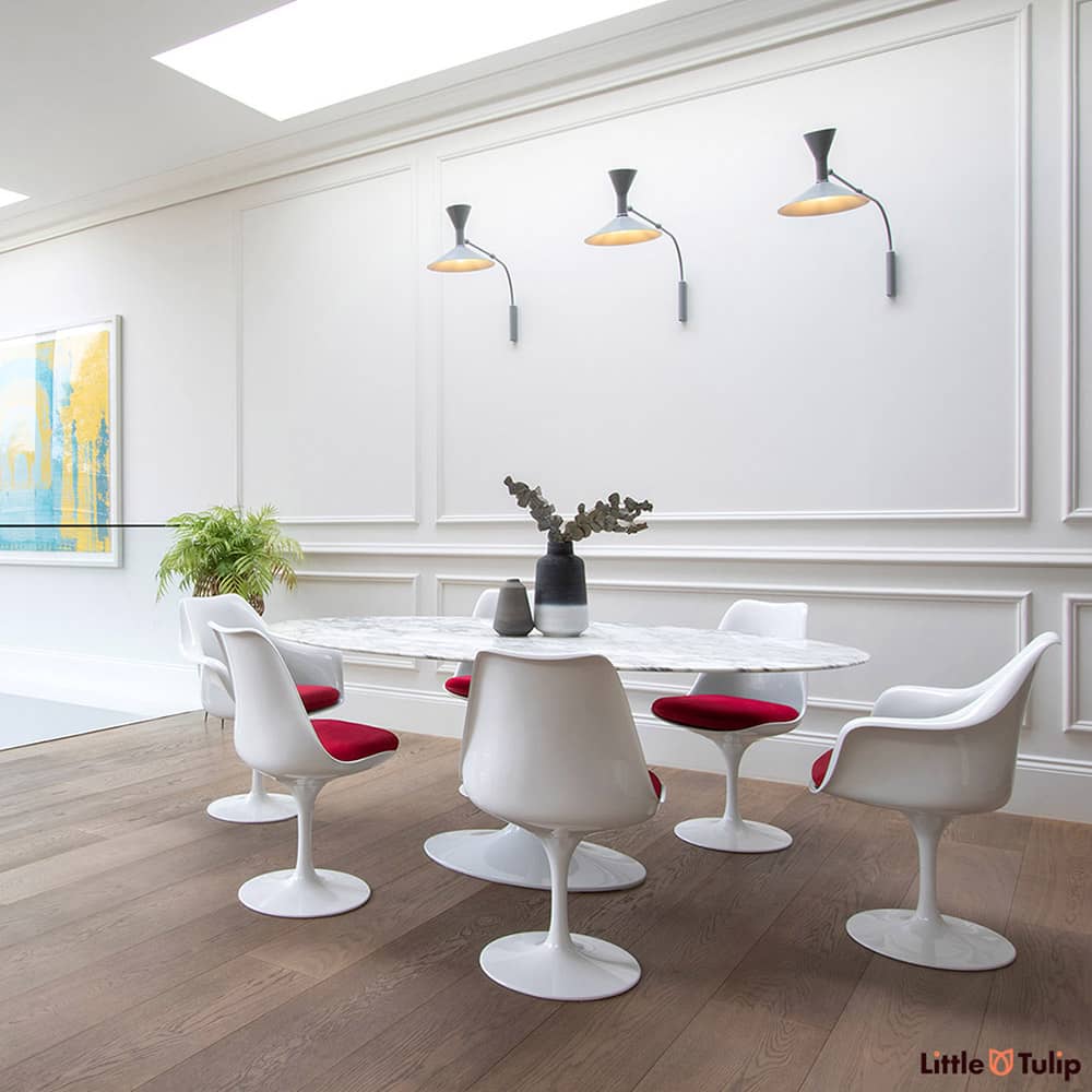 An absolutely gorgeous combination of white space and wooden floor is home to an Arabescato 200 cm Oval table with 4 side & 2 arm chairs with red cushions